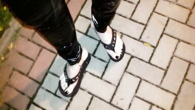 crossdresser on a public street in latex leggings and sexy platform flip flops - 3 image