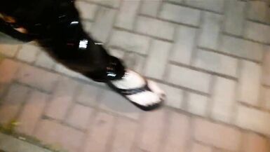 crossdresser on a public street in latex leggings and sexy platform flip flops - 4 image