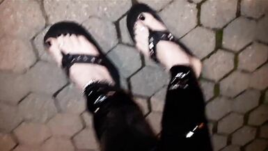 crossdresser on a public street in latex leggings and sexy platform flip flops