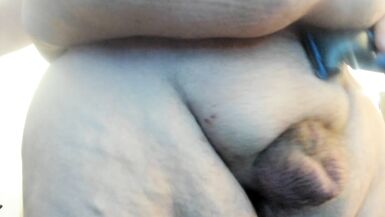 Molly is shaving her genitals while sucking on her dildo.