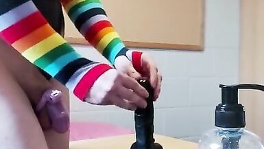 Rainbow Femboy in a Chastity Cage and Shiny Leotard Rides a BBC Dildo - 3 image